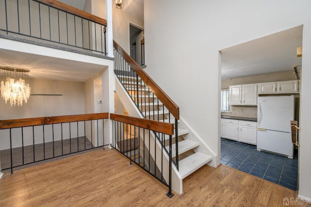 stairway featuring an inviting chandelier and hardwood / wood-style floors