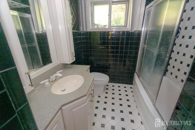 35 Barkalow St, South Amboy, NJ 08879 - full bath featuring tile patterned floors, vanity, bath / shower combo with glass door, tile walls, and toilet