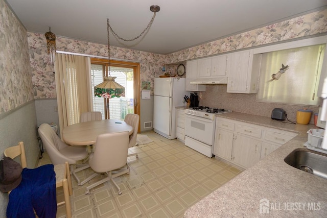 35 Barkalow St, South Amboy, NJ 08879 - kitchen with white appliances, wallpapered walls, under cabinet range hood, light countertops, and light flooring