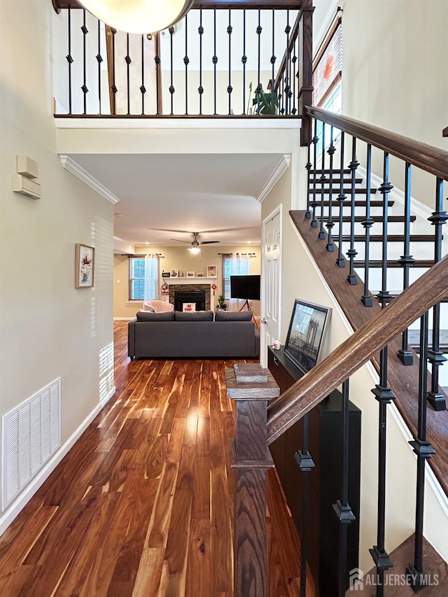 196 Jonathan Pl, Franklin Twsp, NJ 08873 - stairs with a towering ceiling, a fireplace, ornamental molding, wood finished floors, and a ceiling fan