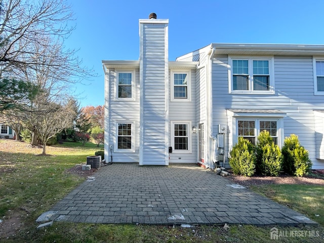 196 Jonathan Pl, Franklin Twsp, NJ 08873 - back of house featuring a chimney, a patio area, and a lawn