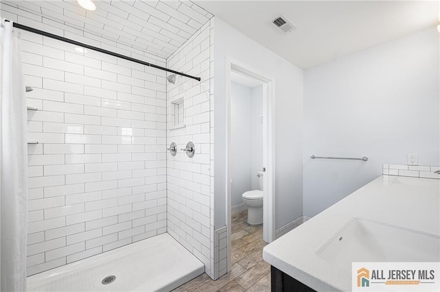 full bath featuring a shower stall, toilet, and double vanity
