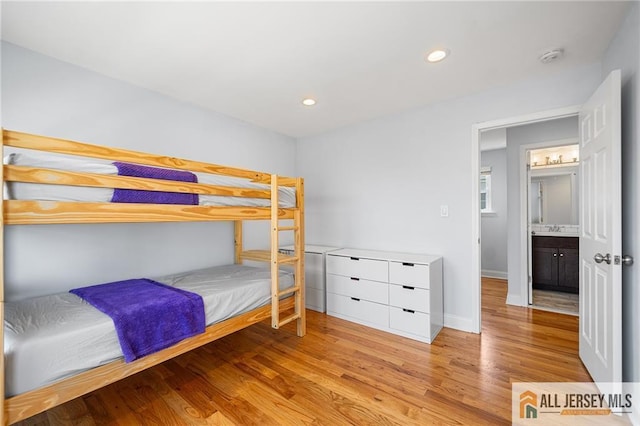 bedroom with wood finished floors, recessed lighting, and baseboards