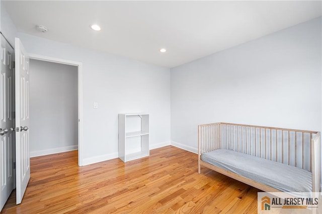 unfurnished bedroom with light wood finished floors, baseboards, and recessed lighting