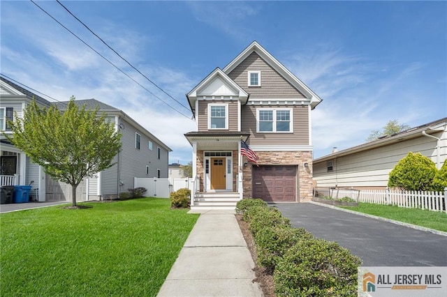view of front of house featuring stone siding, driveway, and an attached garage