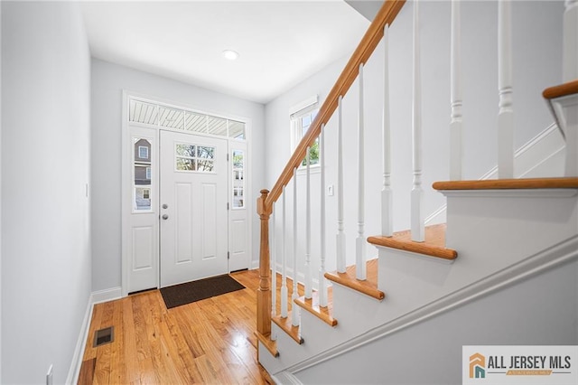 foyer with stairs, wood finished floors, baseboards, and recessed lighting