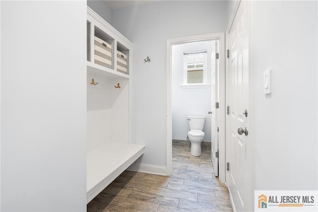 mudroom with wood finished floors and baseboards