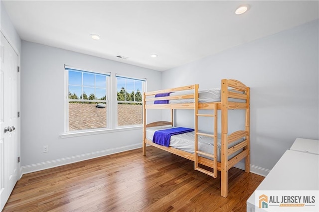bedroom featuring wood finished floors, baseboards, and recessed lighting