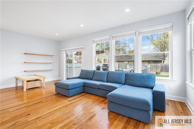 living room featuring light wood finished floors, healthy amount of natural light, recessed lighting, and baseboards