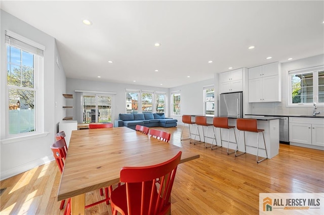 dining area with healthy amount of natural light, recessed lighting, light wood-type flooring, and baseboards