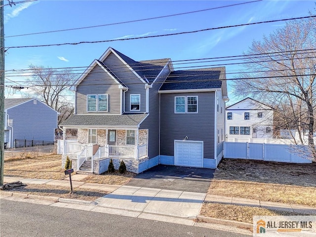 230 Park Ave, Piscataway, NJ 08854 - view of front of property with covered porch, asphalt driveway, a garage, and stone siding