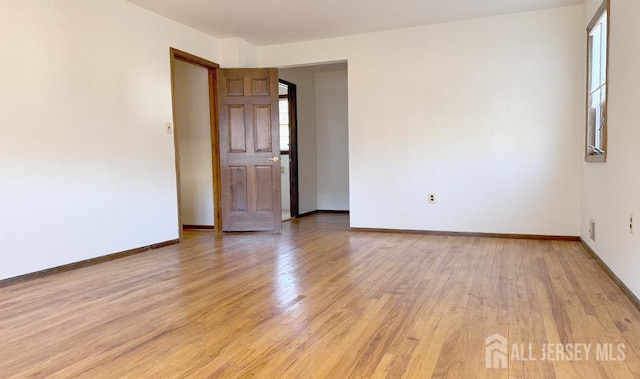 unfurnished room featuring light wood-type flooring and baseboards