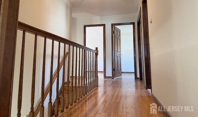 hallway with light wood-type flooring and baseboards