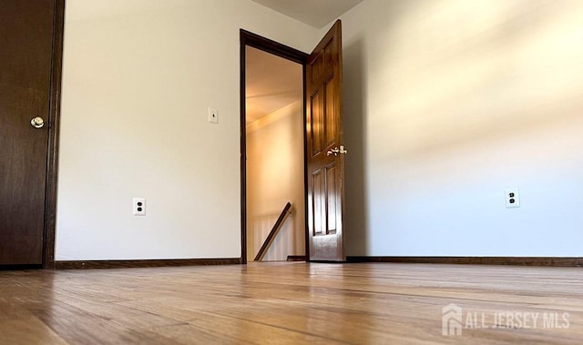 empty room with baseboards and wood finished floors