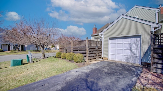 52-C Rutland Ln, Monroe, NJ 08831 - view of side of property with asphalt driveway, a chimney, and a garage