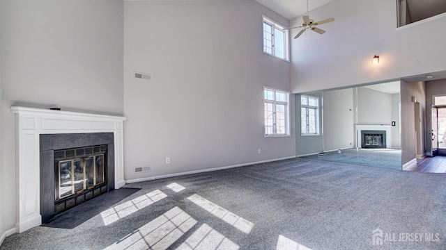 52-C Rutland Ln, Monroe, NJ 08831 - unfurnished living room with a fireplace with flush hearth, carpet flooring, a towering ceiling, a ceiling fan, and baseboards
