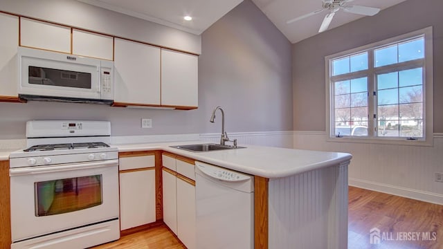 52-C Rutland Ln, Monroe, NJ 08831 - kitchen featuring white appliances, a sink, light wood-style flooring, light countertops, and a wainscoted wall