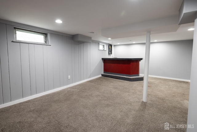 basement with carpet floors, recessed lighting, baseboards, and a dry bar