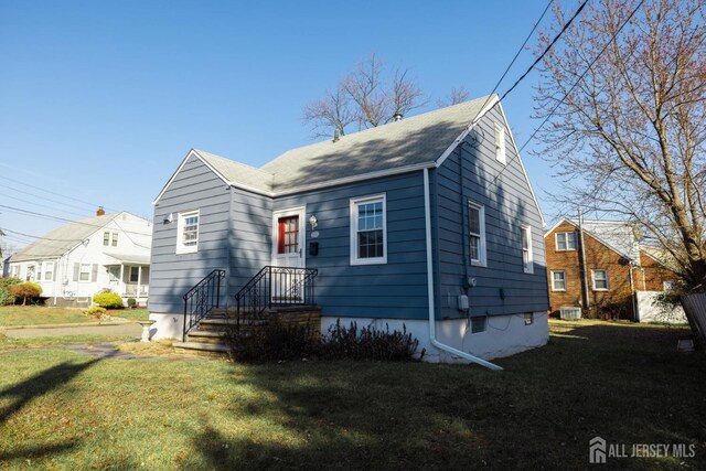 view of front of house featuring central AC and a front lawn