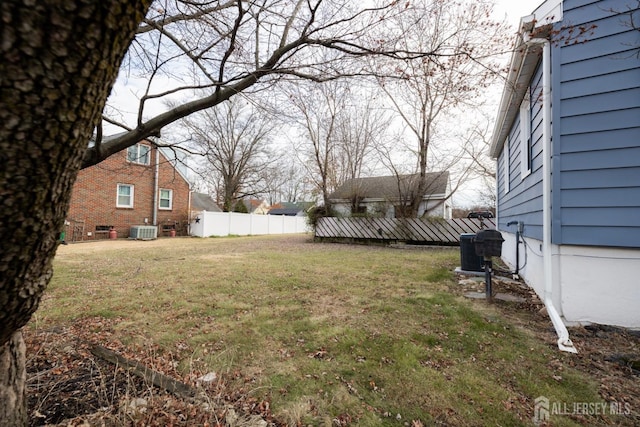 view of yard featuring fence and central air condition unit