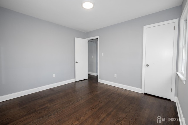 unfurnished bedroom with dark wood-style floors and baseboards