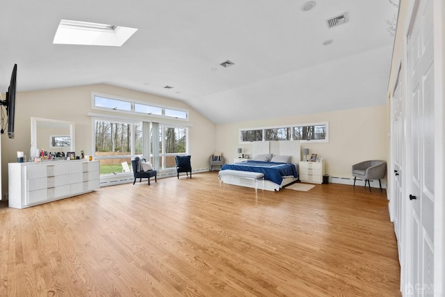 bedroom featuring a baseboard heating unit, light hardwood / wood-style flooring, and lofted ceiling with skylight