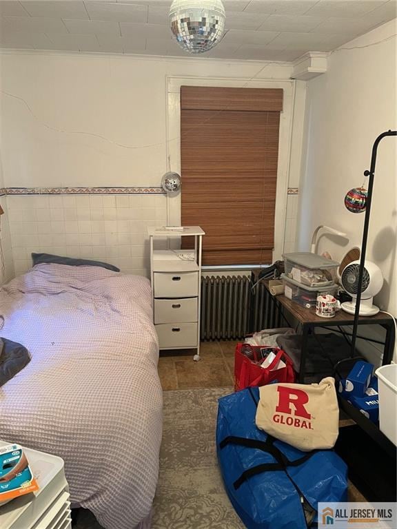 bedroom featuring dark tile patterned flooring and radiator