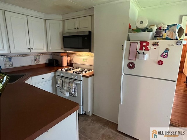 kitchen featuring white cabinets, dark hardwood / wood-style floors, and white appliances