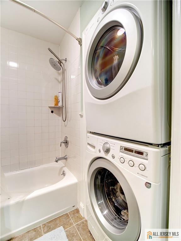 285 Cozzens Ct Unit 285, East Brunswick, NJ 08816 - laundry area with stacked washer / dryer and light tile patterned flooring