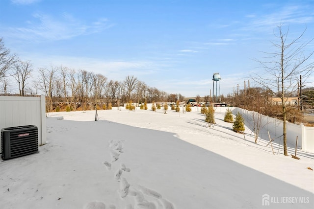 yard covered in snow with fence and central air condition unit