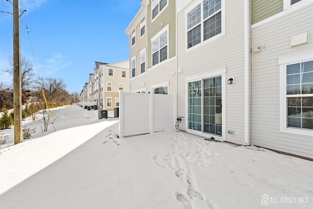 snow covered patio featuring central air condition unit