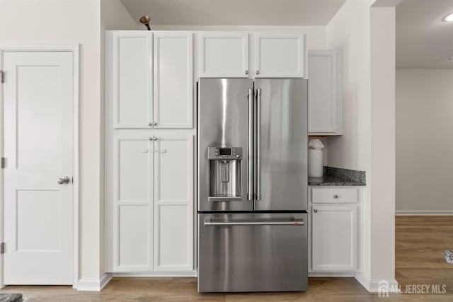 kitchen with baseboards, high end refrigerator, and light wood finished floors