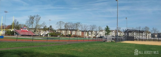 surrounding community with fence, a yard, and a residential view