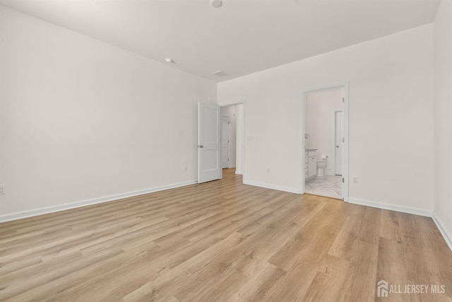 empty room featuring light wood-style floors and baseboards