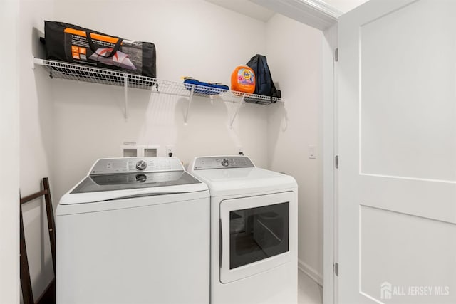 laundry room with baseboards, laundry area, and washer and dryer