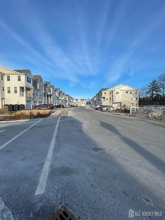 view of street featuring a residential view and curbs