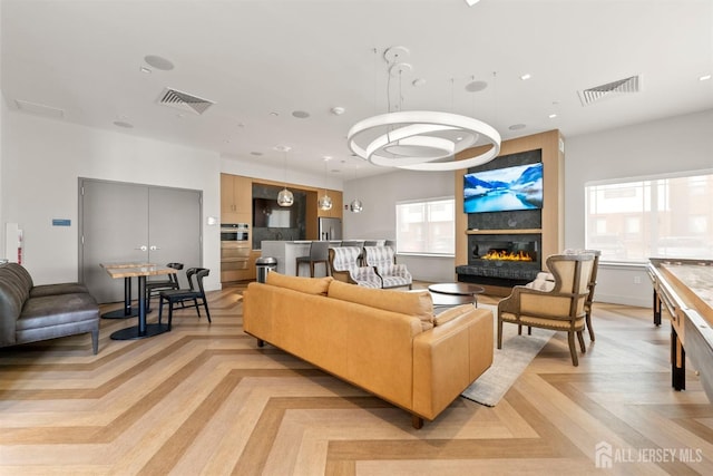 living room with visible vents, a wealth of natural light, and a fireplace