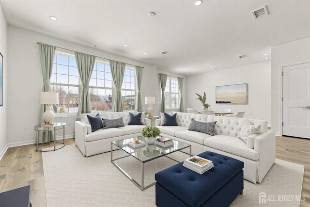 living area featuring plenty of natural light, recessed lighting, wood finished floors, and visible vents