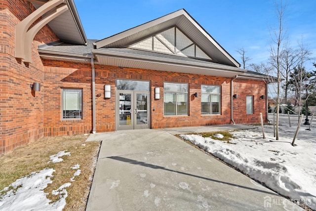 exterior space featuring brick siding and french doors