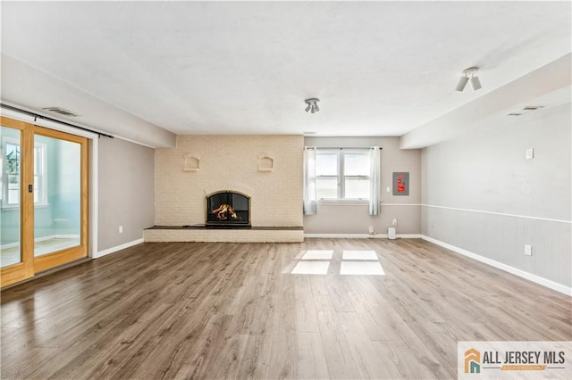 unfurnished living room featuring a fireplace and wood-type flooring