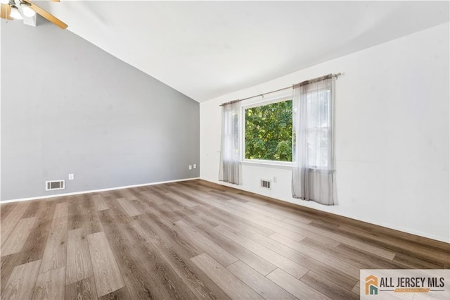 empty room featuring wood-type flooring, ceiling fan, and lofted ceiling