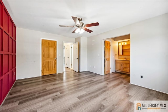 unfurnished bedroom with ensuite bath, ceiling fan, sink, and hardwood / wood-style flooring