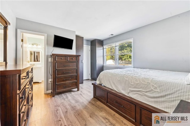 bedroom featuring ensuite bath and light hardwood / wood-style flooring