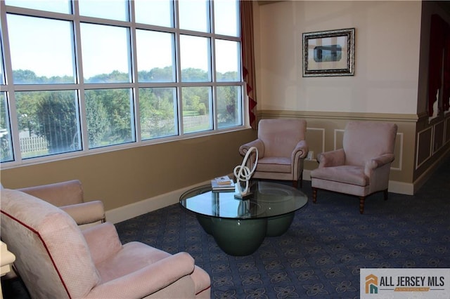 sitting room with a decorative wall and wainscoting