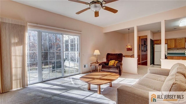 living room with ceiling fan and light colored carpet