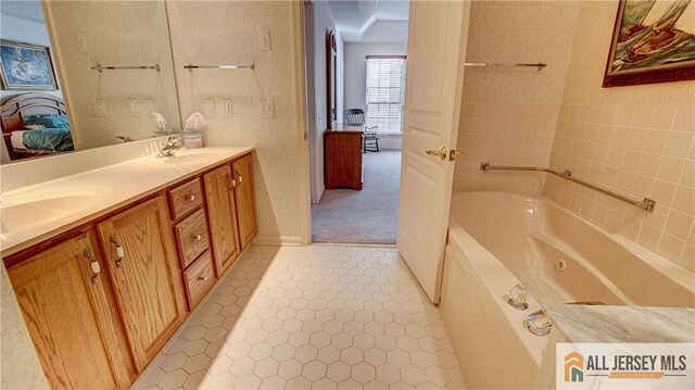 ensuite bathroom with a sink, double vanity, a jetted tub, and connected bathroom