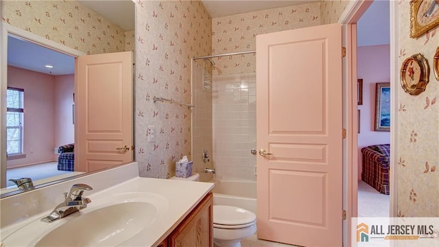 ensuite bathroom with ensuite bathroom, toilet, and wallpapered walls