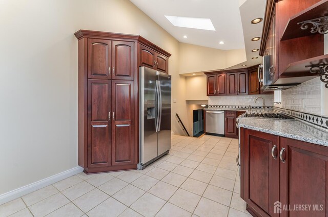 104 Laurel Ave, South Plainfield, NJ 07080 - kitchen with stainless steel appliances, a skylight, tasteful backsplash, light tile patterned flooring, and vaulted ceiling