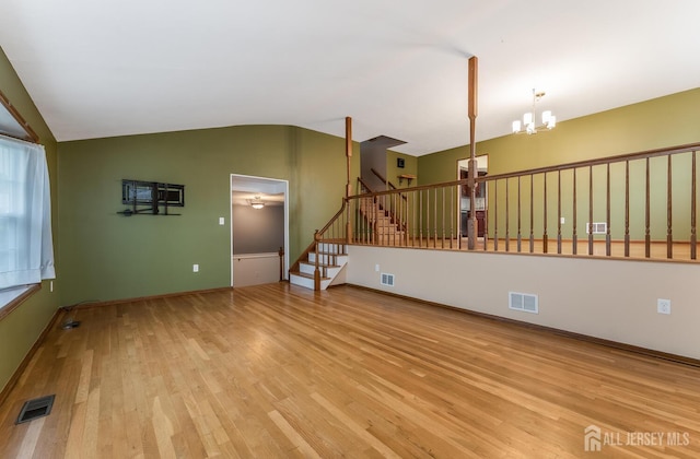 104 Laurel Ave, South Plainfield, NJ 07080 - unfurnished living room featuring a chandelier, lofted ceiling, wood finished floors, and stairs