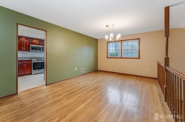 104 Laurel Ave, South Plainfield, NJ 07080 - spare room with light wood-type flooring and a chandelier
